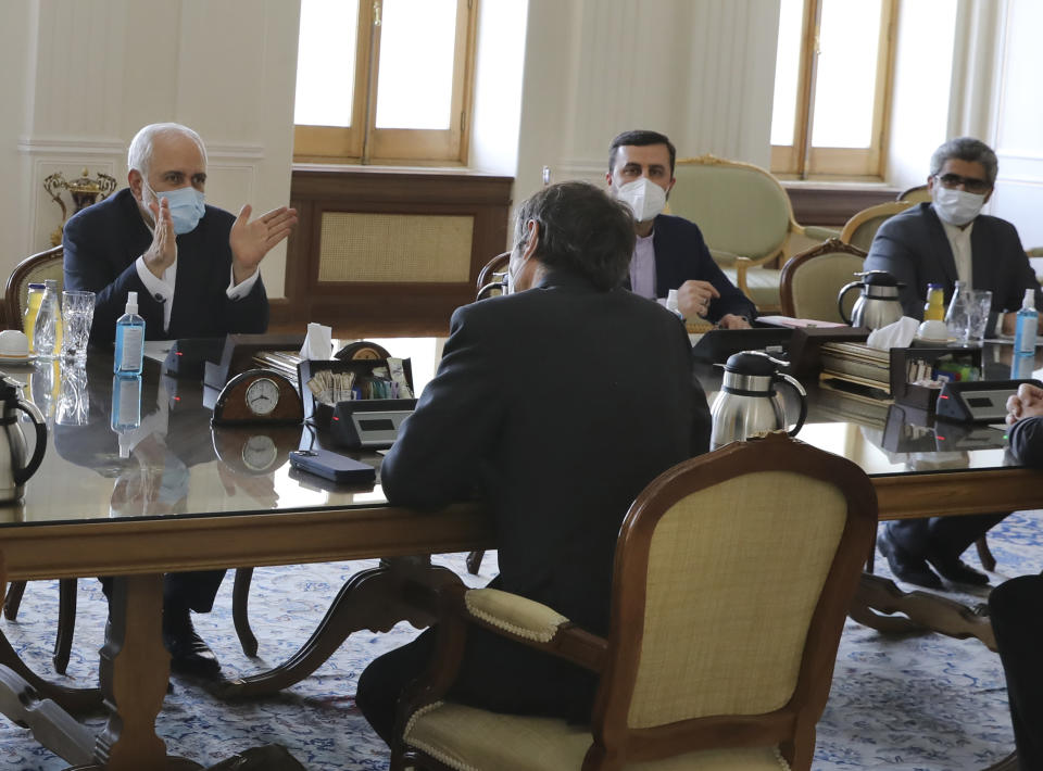 Iranian Foreign Minister Mohammad Javad Zarif, right, speaks with Director General of International Atomic Energy Agency, IAEA, Rafael Mariano Grossi, back to camera at center, during their meeting in Tehran, Iran, Sunday, Feb. 21, 2021. The head of the United Nations' nuclear watchdog met Sunday with Iranian officials in a bid to preserve his inspectors' ability to monitor Tehran's atomic program, even as authorities said they planned to cut off surveillance cameras at those sites. (AP Photo)