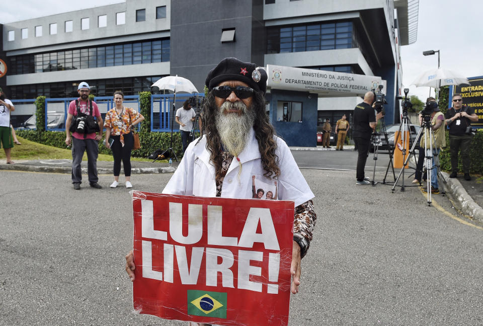 Supporter of former Brazilian President Luiz Inacio Lula da Silva holds a sign that reads "Free Lula", outside the Federal Police Department, in Curitiba, Brazil, Wednesday, Dec. 19, 2018. Lawyers representing the former leader say they have applied for his release following a legal ruling from a Supreme Court judge. Judge Marco Aurelio ruled Wednesday that individuals who have been convicted, but are at early stage of appeals, should be set free. The judge's decision would apply to da Silva who has been in prison since April and is appealing a conviction for corruption that led to a sentence of just over 12 years in prison. (AP Photo/Denis Ferreira)