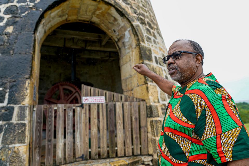 Dorbrene O'Marde, chairman of the Antigua and Barbuda Reparations Commission, talks about how sugar mills were once key to the country's economy during a visit to Betty's Hope, a former plantation.