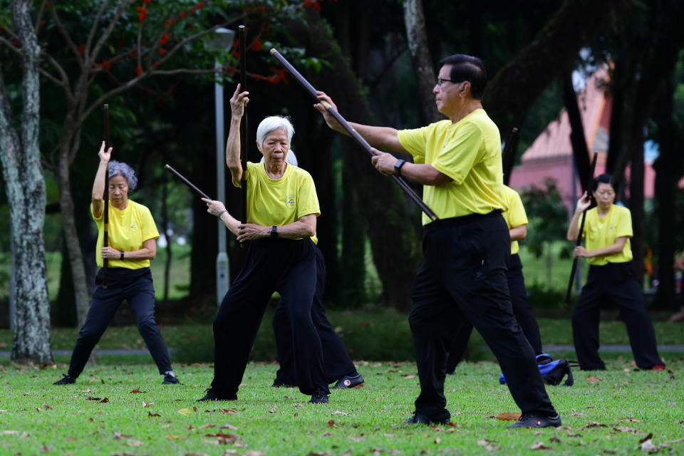 Elderly people practise tai chi at a park in Singapore.