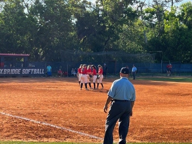 The Oxbridge Academy softball team huddles during a second round playoff game against AIE (Miami Shores) in West Palm Beach on May 16, 2023.