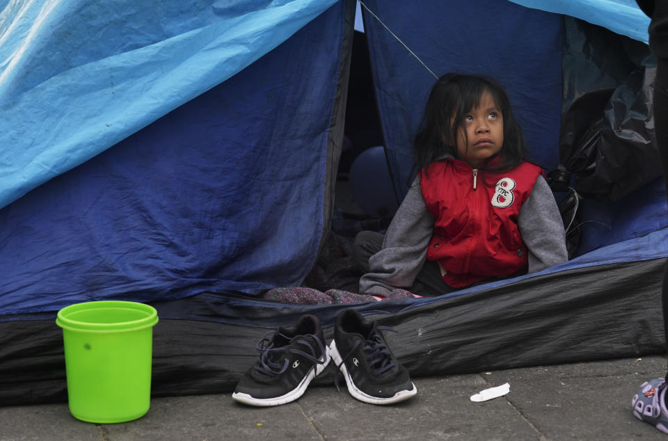 A young migrant camps outside the Church of Santa Cruz y La Soledad in Mexico City, Tuesday, Dec. 26, 2023. (AP Photo/Marco Ugarte)
