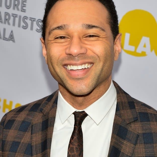 Corbin in a patterned suit and tie smiling at a gala event