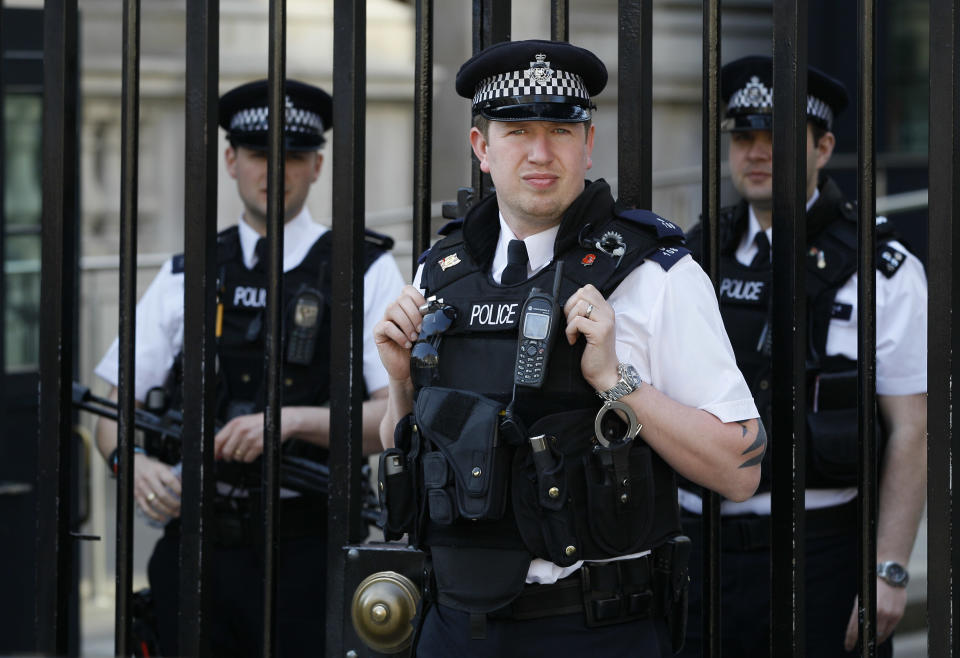 Police officers keep watch at Downing Street in Westminster near the London 2012 beach volleyball venue, in London, Wednesday, March 28, 2012. Britain's spy agencies and police have planned for a dizzying array of security nightmares surrounding the Olympics a coordinated terror attack like the 2005 suicide bombings, a dirty bomb, a cyberattack and hoaxes designed to scatter personnel.(AP Photo/Kirsty Wigglesworth)