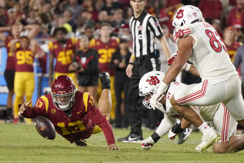 Southern California quarterback Caleb Williams, left, recovers the ball after his fumble as Utah defensive tackle Keanu Tanuvasa, center, and defensive end Jonah Elliss dive for it during the second half of an NCAA college football game Saturday, Oct. 21, 2023, in Los Angeles. (AP Photo/Mark J. Terrill)