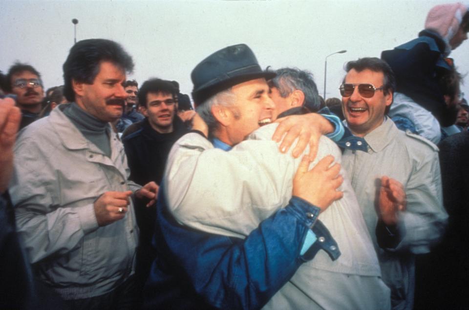 (GERMANY OUT) Germany / GDR, Berlin. The fall of the wall. People from East and West hugging. 1989 (Photo by Günter Peters/ullstein bild via Getty Images)