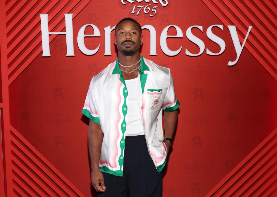 Michael standing in front of a Hennessy sign