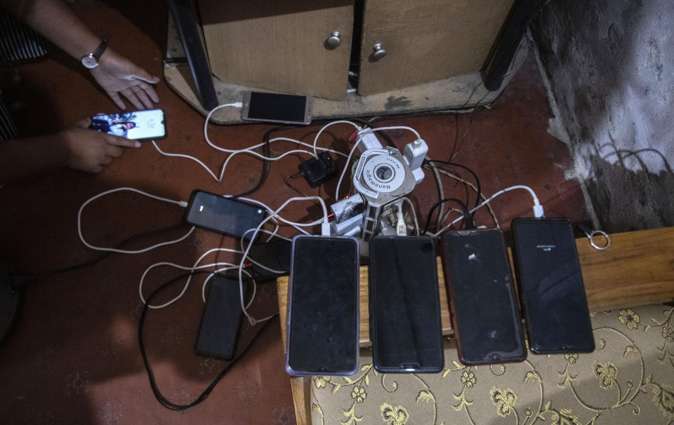 Mobile phones of police officers, who fled Myanmar following a military coup, lie on charge at an undisclosed location bordering Myanmar, in the northeastern Indian state of Mizoram, Thursday, March 18, 2021. Villagers in Mizoram have given shelter to 34 Myanmar police personnel and 1 fire fighter, who crossed over to the state over the last two weeks. Those who escaped spend their time watching local television and doing daily chores. Some of them have carried mobile phones and are trying to connect to families they were forced to leave behind. At night, all of them go to sleep on mattresses laid on the floor of a single room. (AP Photo/Anupam Nath)
