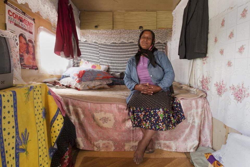 A woman poses inside a caravan in a Gypsy camp in Wissous, outside Paris, Wednesday Aug. 22, 2012. French Prime Minister Jean-Marie Ayrault was to host a meeting of ministers on the issue of Roma, or Gypsies, in France after the government launched its latest campaign this month to drive them from their camps.(AP Photo/Jacques Brinon)