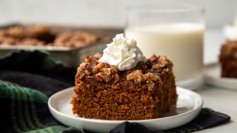 gingerbread pecan cake slice with whipped cream