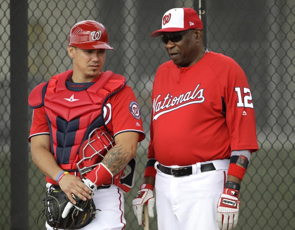 Washington Nationals manager Dusty Baker (12) talks with catcher Jose Lobaton during a spring training baseball workout Thursday, Feb. 16, 2017, in West Palm Beach, Fla. (AP Photo/David J. Phillip)