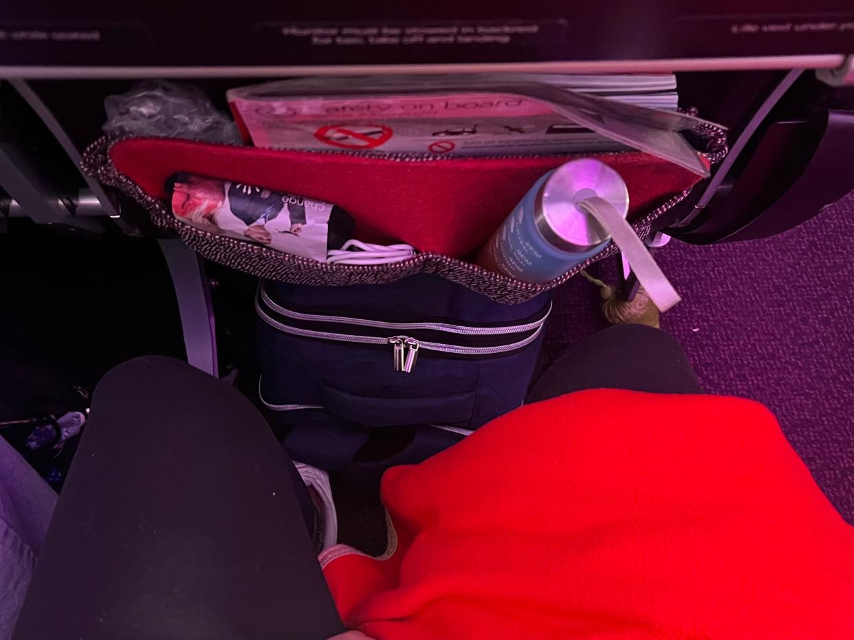 The author's legroom with a blue backpack under the seat in front.