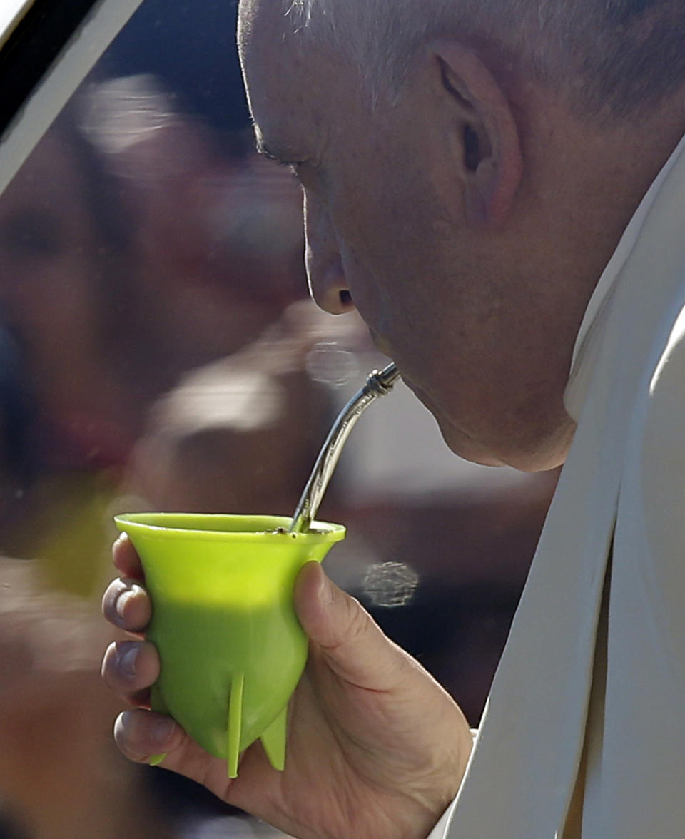 Pope Francis drinks from a mate gourd, a traditional South American cup, that was offered by Maximiliano Costantino a pilgrim from Cordoba, Argentina, as the Pontiff was touring with his pope-mobile St. Peter's Square on the occasion of the weekly general audience at the Vatican, Wednesday, April 16, 2014. (AP Photo/Gregorio Borgia)