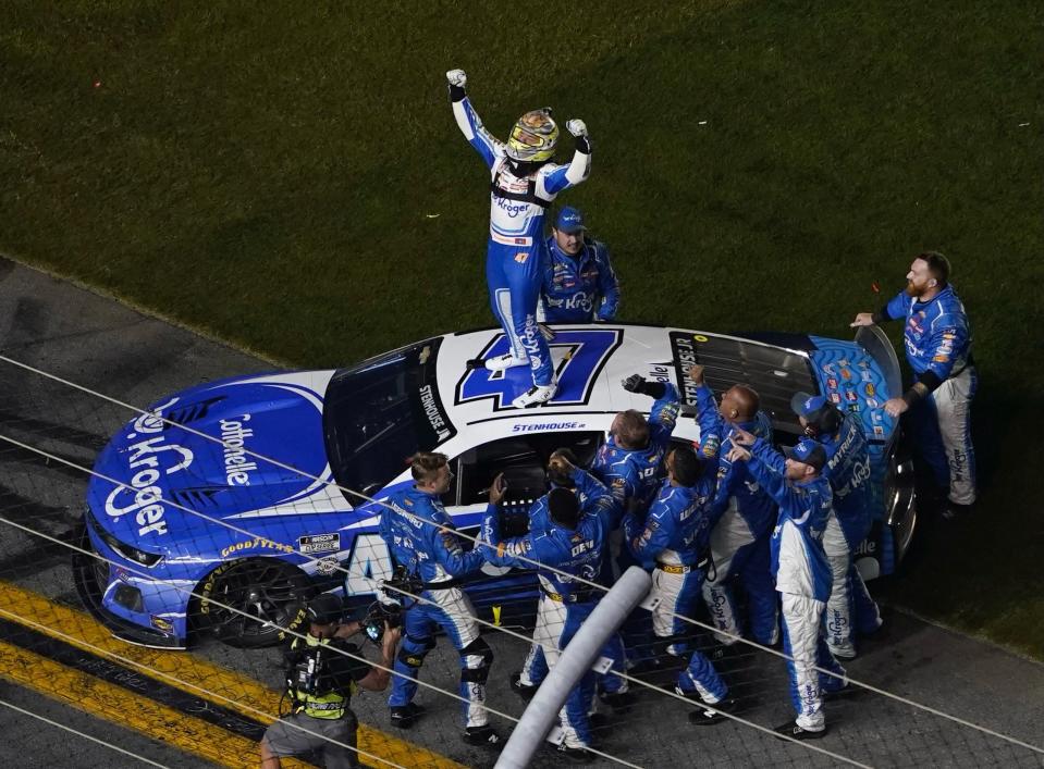 Ricky Stenhouse stands on top of his car as his crew celebrates around him after winning the 65th Daytona 500.
