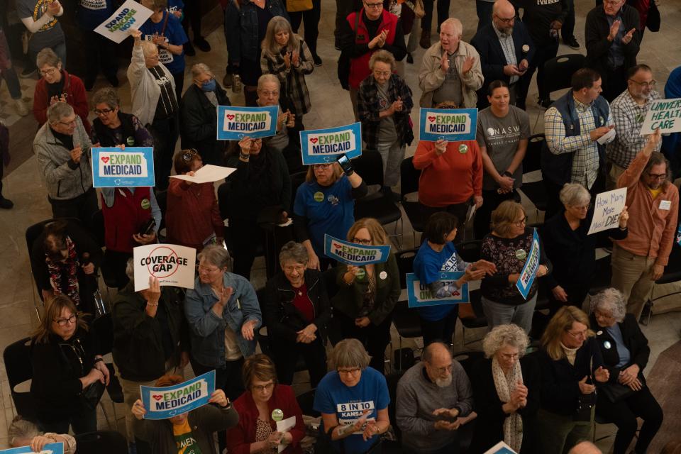 Medicaid expansion supporters hold signs during a rally Wednesday, March 6, 2024 inside the Kansas Statehouse.