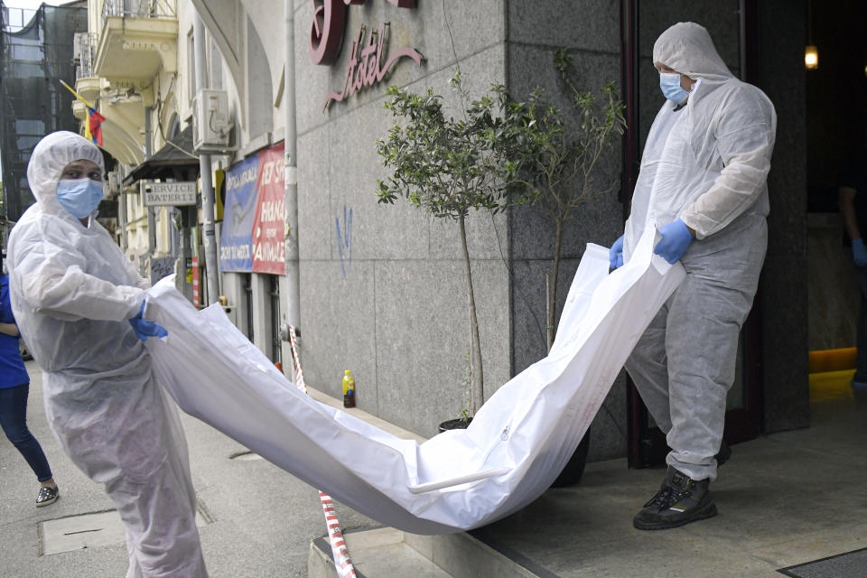 Forensic worker carry a body from a hotel downtown Bucharest, Romania, Friday, June 19, 2020. Gholamreza Mansouri, a former judge from Iran sought by his country to face corruption charges has died in unusual circumstances, Romanian media reported. Romanian police said only that a man had fallen from a high floor at a hotel in Bucharest, the Romanian capital, and was found dead. (AP Photo/Andreea Alexandru)