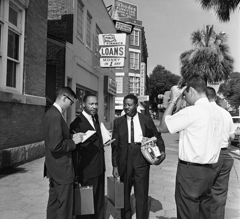 <p>Integration leader Martin Luther King, Jr., second from left, talks to a newsman on July 12, 1962, after he and Rev. Ralph Abernathy, second from right, walked out of jail after their fines were paid. Both said they did not know who paid the $178 fines. Far right is an unidentified city detective. Police arrested 32 African American demonstrators on July, 11, 1962 in Albany, Ga., when the group tried to march on City Hall. (AP Photo) </p>