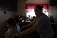 Eugenia Rodriguez, right, maneuvers the wheelchair with her 84-year-old mother, Francisca Perez, who suffers from a heart condition, rheumatoid arthritis and depression, among other ailments, Wednesday, June 30, 2021, in their house in Chicago's Little Village neighborhood. Rodriguez hasn't been eligible for insurance coverage after overstaying a visitor visa from Mexico. She used to wake up every two or three hours at night to check on her mother. Since getting health insurance through the Illinois program, her mother has all the medications she needs. (AP Photo/Shafkat Anowar)