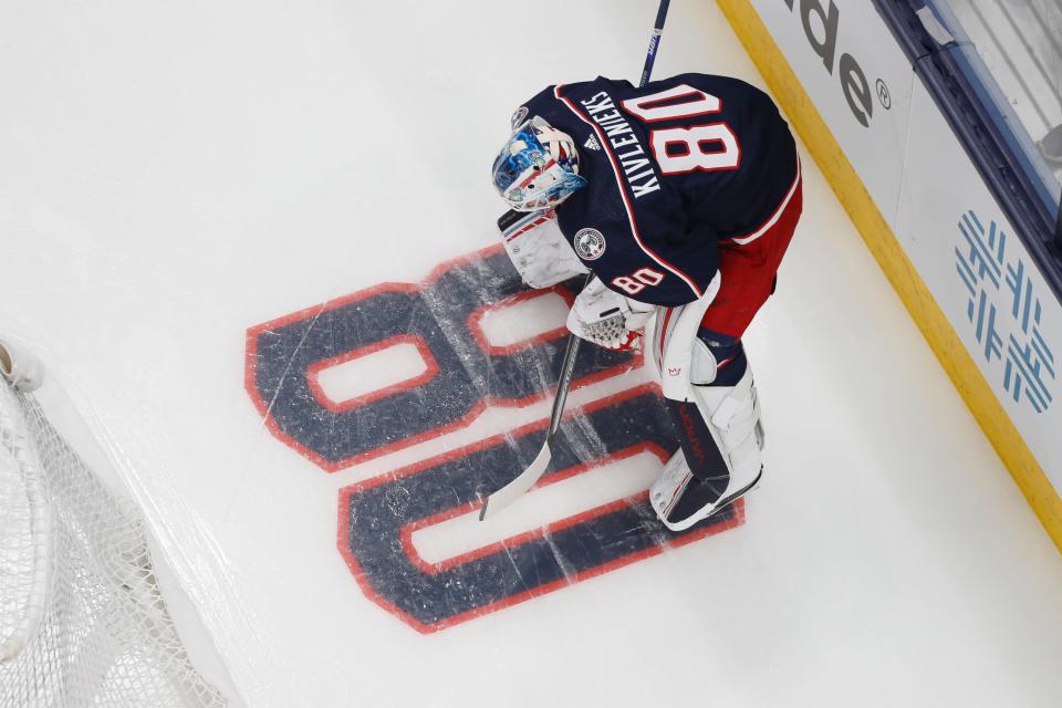 With an 80 painted in the ice, Columbus Blue Jackets goaltender Elvis Merzlikins wears Matiss Kivlenieks jersey for warm-ups prior to the season opening NHL hockey game against the Arizona Coyotes at Nationwide Arena in Columbus on Thursday, Oct. 14, 2021. 