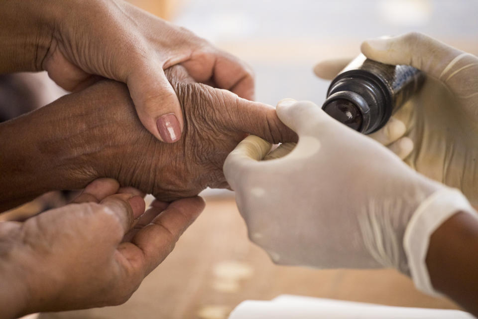 Rosa Jimenez, 97, gets her finger stained with ink as proof of having cast her ballot during the presidential elections, in Santo Domingo, Dominican Republic, Sunday, July 5, 2020. (AP Photo/Tatiana Fernandez)