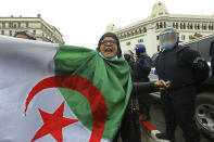 A woman holds an Algerian flag as Algerians demonstrate in Algiers to mark the second anniversary of the Hirak movement, Monday Feb. 22, 2021. February 22 marks the second anniversary of Hirak, the popular movement that led to the fall of Algerian President Abdelaziz Bouteflika. (AP Photo/Anis Belghoul)