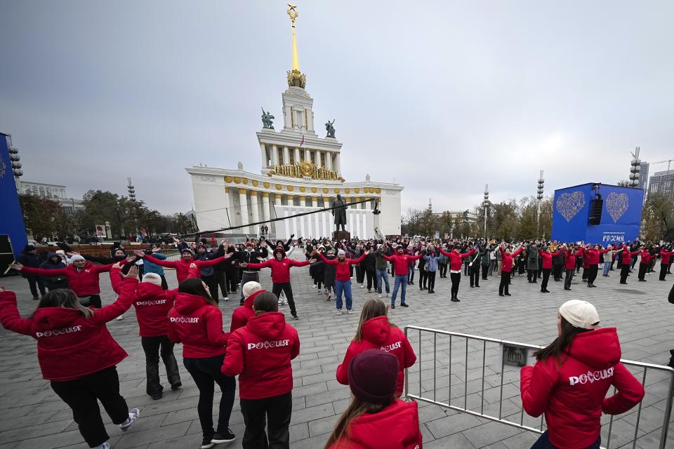 Volunteers perform during opening of the International exhibition "Russia" at VDNKh (The Exhibition of Achievements of National Economy) in Moscow, Russia, Saturday, Nov. 4, 2023. The vast show was put together under a decree from President Vladimir Putin and is seen as encouraging patriotism in the runup to the presidential election in March. (AP Photo/Alexander Zemlianichenko)