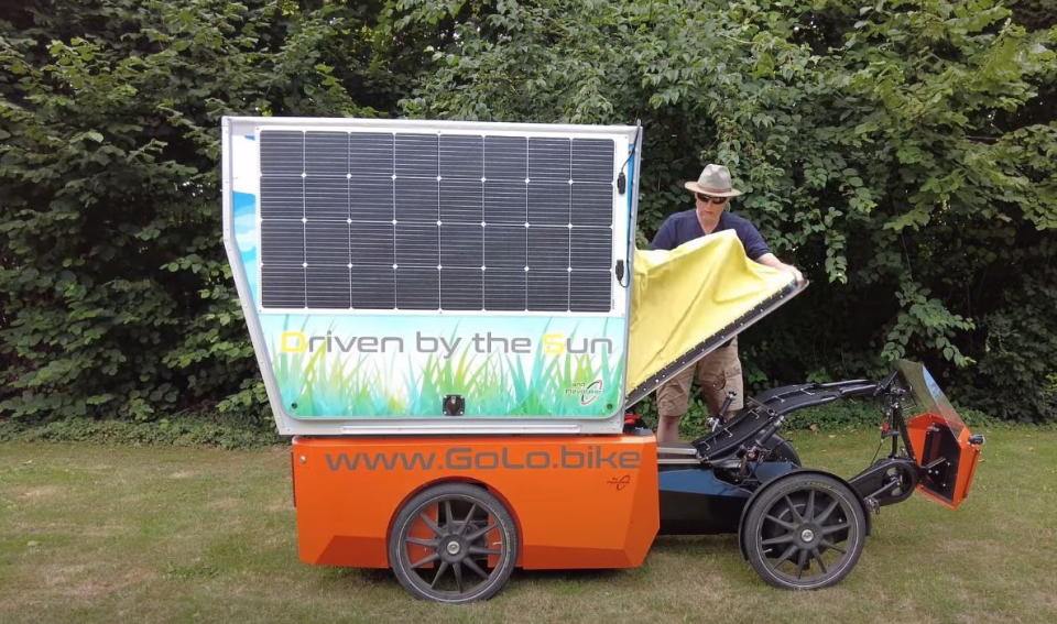 Man pops up the cycling canopy on his GoLo GoCamp to shade himself as he pedals.