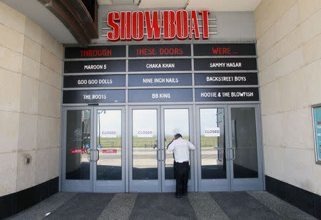 A man tries to peek into the closed Showboat Casino Hotel in Atlantic City, New Jersey September 1, 2014. REUTERS/Tom Mihalek