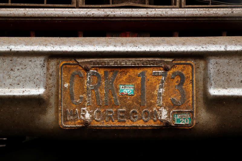 The ash-covered Oregon license plate is seen on a car outside a home destroyed by fire during the aftermath of the Riverside Fire near Molalla, Oregon
