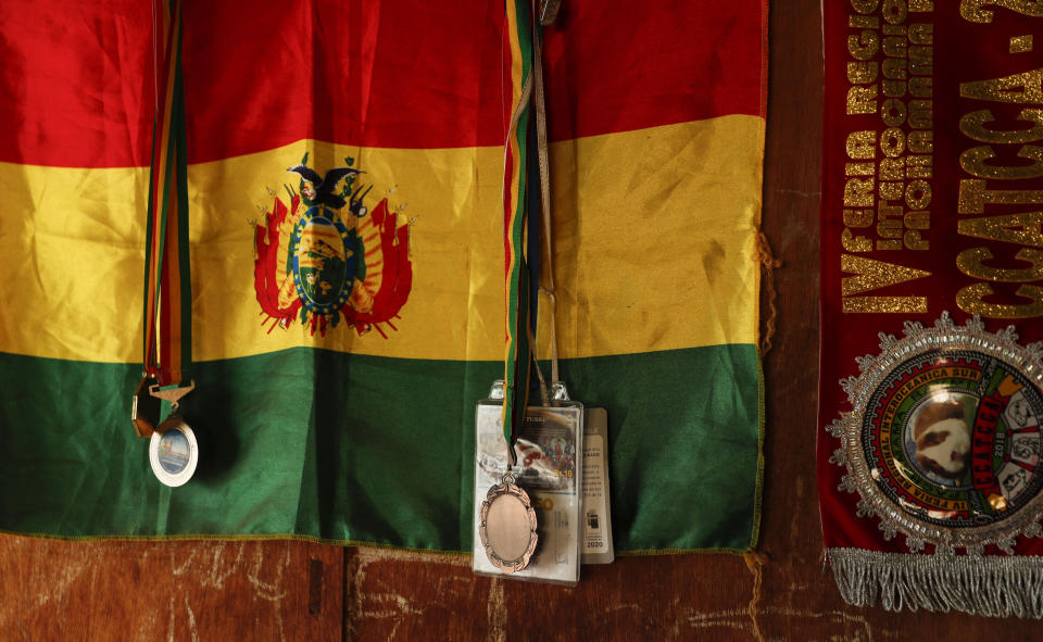 A Bolivian flag hangs behind the boxing medals of Gracce Kelly Flores, a 12-year-old boxer who goes by the nickname Hands of Stone, at her home in Palca, Bolivia, Thursday, June 10, 2021. At age 8, Flores defeated a 10-year-old boy, and with three national boxing medals under her belt, she dreams of reaching the women's boxing world championship. (AP Photo/Juan Karita)