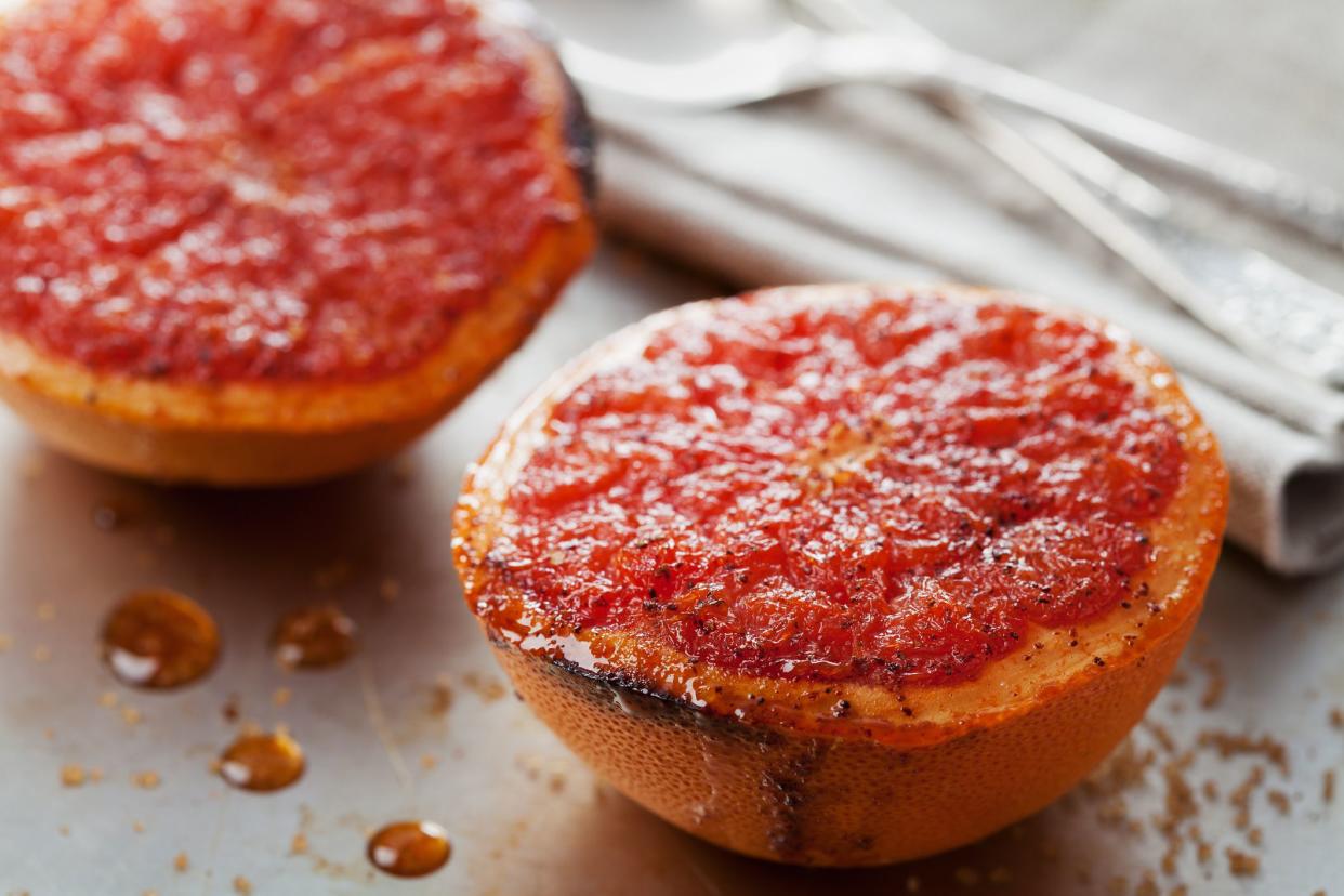 Vintage image of broiled grapefruit with brown sugar and cinnamon on metal surface, healthy dessert is good for breakfast or snacks