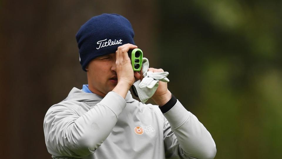 a photo of a man holding a golf rangefinder