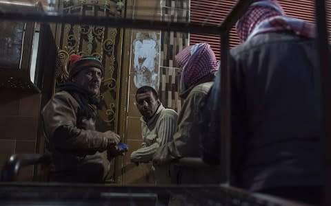 Men queue up to buy bread outside a bakery on te hotskirts of Qamishli - Credit: Sam Tarling