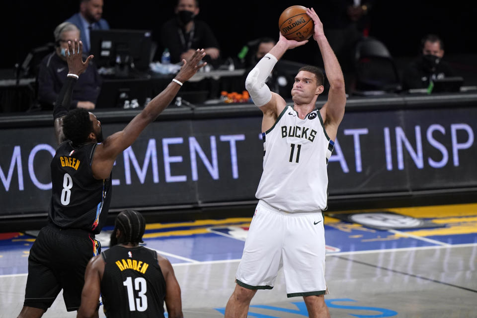 Milwaukee Bucks center Brook Lopez (11) shoots over Brooklyn Nets forward Jeff Green (8) and guard James Harden (13) during the first half of Game 5 of a second-round NBA basketball playoff series Tuesday, June 15, 2021, in New York. (AP Photo/Kathy Willens)