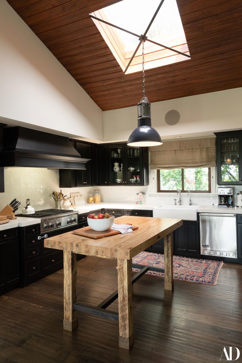 In the Beverly Hills house John Stamos shares with his wife, Caitlin, and son, Billy, the kitchen is modern but rustic thanks to the furnishings, which include black cabinets and a reclaimed-wood table for preparation. Stamos shares: “We cook in the kitchen and outside, where I have a pizza oven. That was Caitlin's and my first date: She said she liked pizza!”