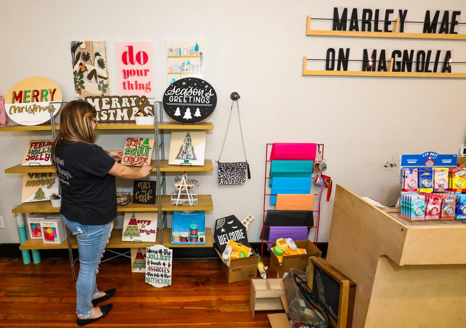 Jennifer Arvanitis, owner of Marley Mae Market & Paperie, a gift and stationery shop located in downtown Ocala, displays the holiday signs that she makes while talking about how the community supports her business during Small Business Saturday.