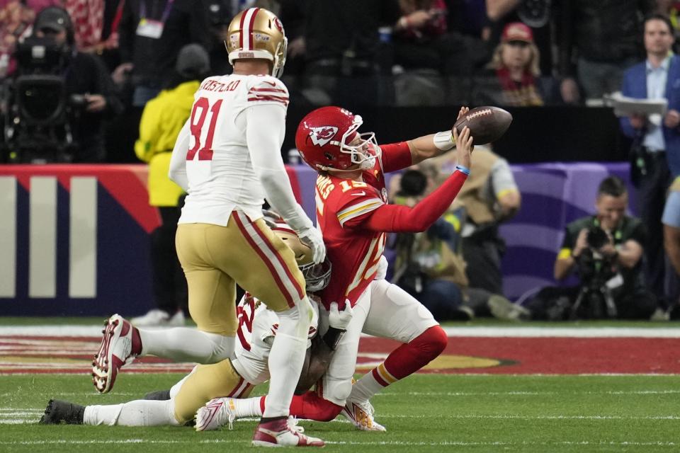 Kansas City Chiefs quarterback Patrick Mahomes (15) tries to throw the ball as he is hit by San Francisco 49ers defensive end Chase Young (92) during the first half of the NFL Super Bowl 58 football game Sunday, Feb. 11, 2024, in Las Vegas. (AP Photo/Abbie Parr)