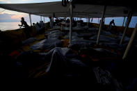 <p>Varios inmigrantes duermen a bordo durante la travesía de Proactiva por el Mediterráneo (REUTERS/Juan Medina). </p>