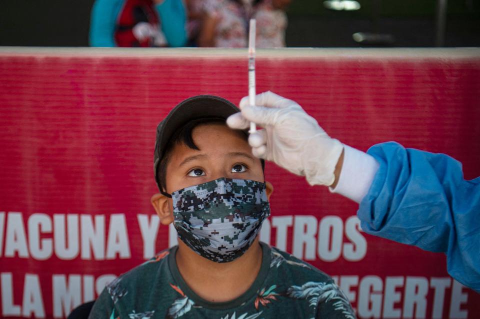 A health worker prepares to inoculate a child with a dose of the Pfizer-BioNTech vaccine against COVID-19 during a vaccination campaign in Lima, on January 25, 2022, amid the coronavirus pandemic. Peru began vaccinating children aged five to 11 against COVID-19 on Monday, as the country is on track to surpass three million cases due to a sharp rise in infections driven by the omicron variant. 