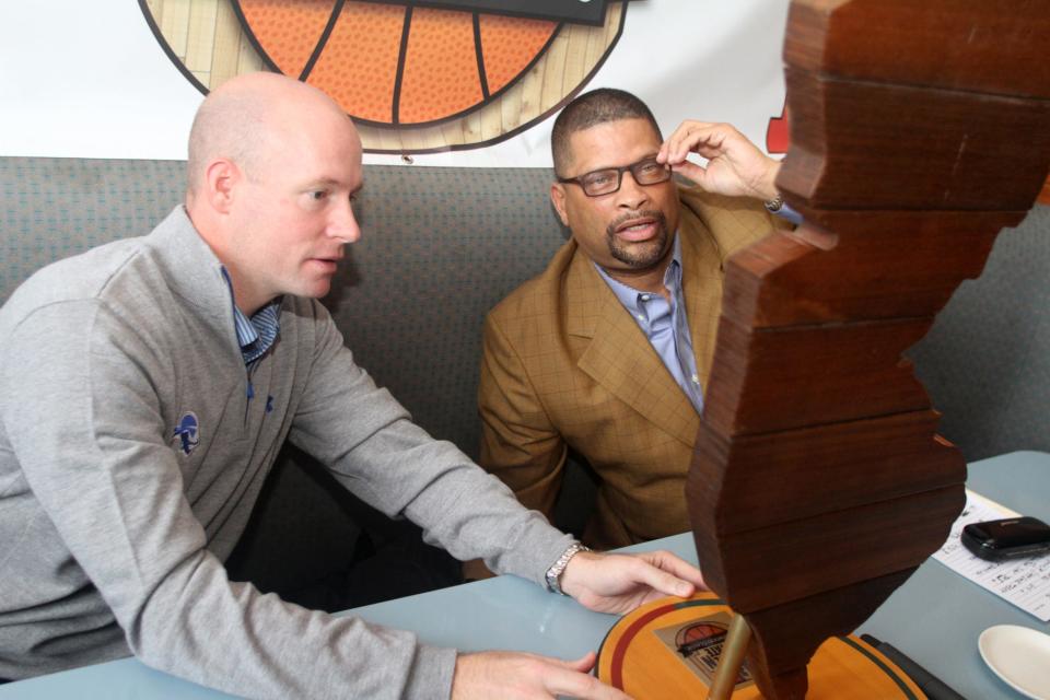 Seton Hall basketball coach Kevin Willard and Rutgers coach Eddie Jordan examine the trophy crafted of wood from the Sandy-damaged Asbury Park boardwalk, Wednesday, December 3, 2014