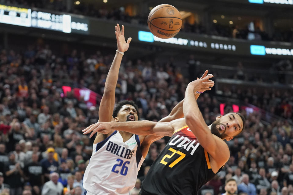 Dallas Mavericks guard Spencer Dinwiddie (26) loses control of the ball defended by Utah Jazz center Rudy Gobert (27) in the first half of Game 6 of an NBA basketball first-round playoff series, Thursday, April 28, 2022, in Salt Lake City. (AP Photo/Rick Bowmer)