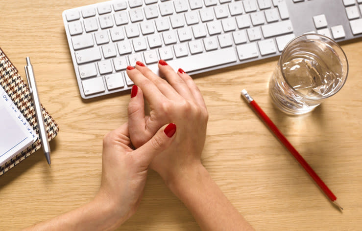 Closeup of a woman's hands next to her computer