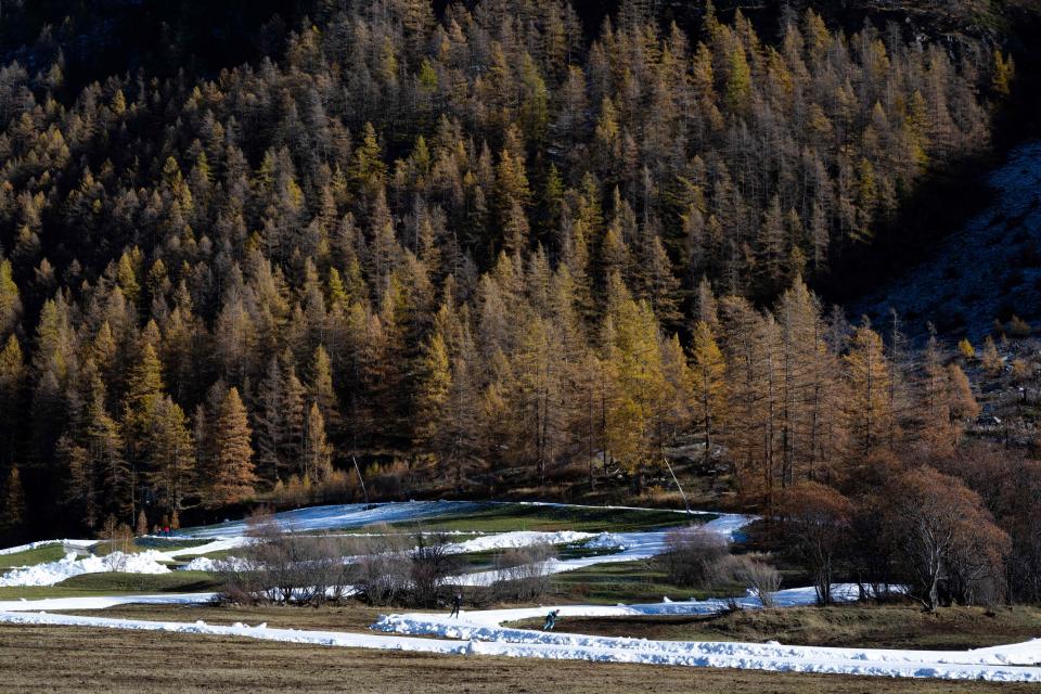 Skiers practise Nordic skiing in the small Savoyard village of Bessans on November 6, 2022. - After a hot summer, snow has finally sprinkled the Alps. But the small Savoyard resort of Bessans is launching its Nordic ski season this weekend by offering... last year's snow, from 