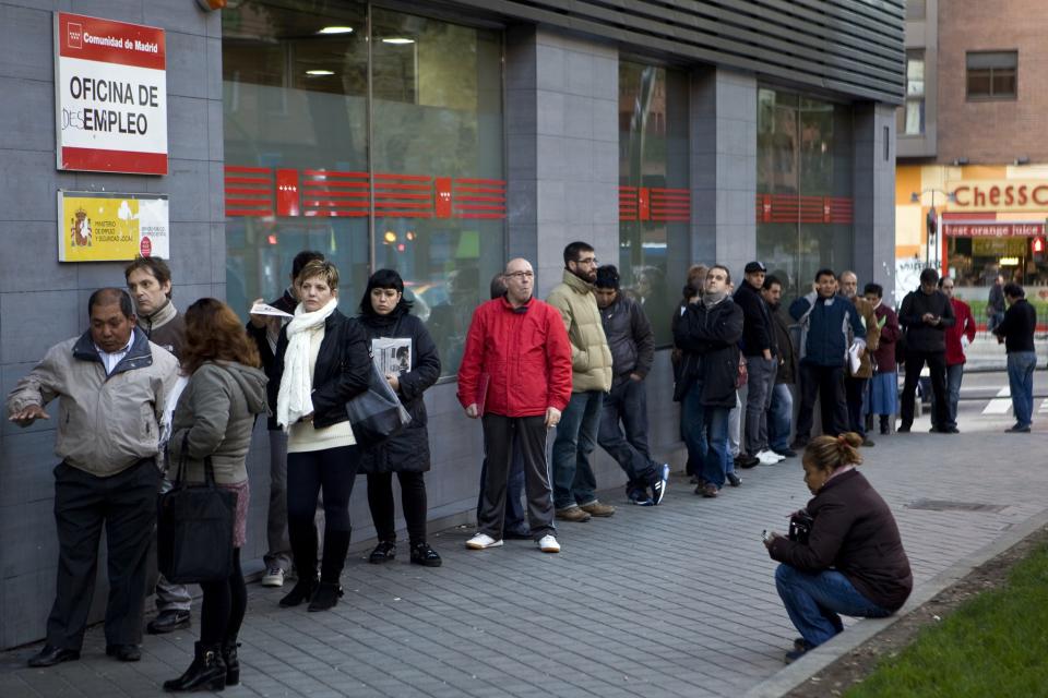 Varias personas esperan a las puertas de una oficina de empleo de Madrid.