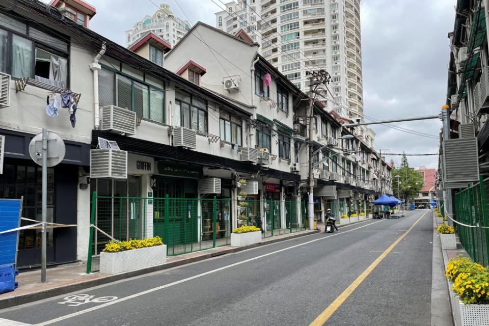 上海部分地區再啟動「硬隔離」措施，街道兩旁的商店住宅出口被用綠色圍欄封鎖住。（路透）