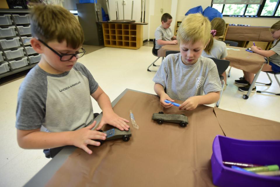 Jaxon Dobbie (left) and Cohen Tucker (right) decorate their pinewood derby cars during the Port Huron Police Department's annual Law Enforcement Elementary Camp on Wednesday, June 22, 2022, at Garfield Elementary School in Port Huron.