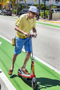 Older man on a scooter in a bike lane