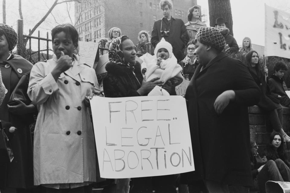 Protestors, one holding a child, stand around a placard reading 'Free legal abortion' during a mass demonstration against New York State abortion laws, in the Manhattan borough of New York City, New York, 28th March 1970. (Photo by Graphic House/Hulton Archive/Getty Images)