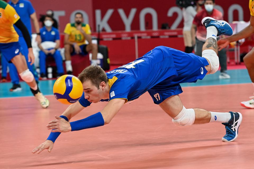 <p>Brazil's Thales Hoss dives for the ball in the men's preliminary round pool B volleyball match between Brazil and USA during the Tokyo 2020 Olympic Games at Ariake Arena in Tokyo on July 30, 2021. (Photo by ANGELA WEISS / AFP)</p> 