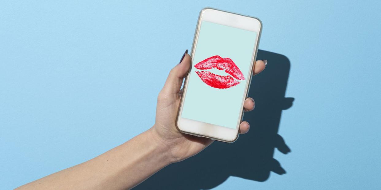 woman's hand shows her smartphone with lipstick kiss